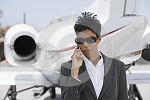 Confident Businesswoman Using Cellphone At Airfield photo