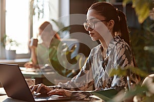 Confident Businesswoman Using Computer with Sunlight