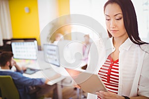 Confident businesswoman using digital tablet at creative office