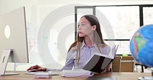 Confident businesswoman writing in notepad at desk in office