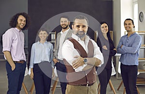 Confident caucasian businessman standing with folded arms smiling at camera