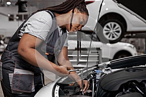 Confident Caucasian Female Mechanic is Working With Car In Car Service