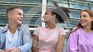 Confident caucasian teen boy getting acquainted with nice female friends, flirt