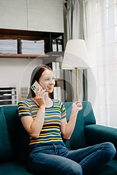 Confident Caucasian woman with a smile standing holding notepad and tablet in living room on the sofa at office