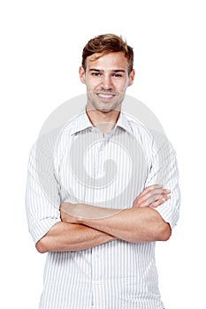 Confident and charming. Studio portrait of a young man standing with his arms crossed against a white background.