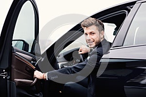 Young businessman driving alone in his luxury car