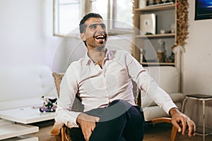 Confident and cheerful Syrian man is listening to a conversation