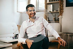 Confident and cheerful Syrian man is listening to a conversation