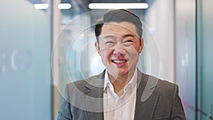 Confident chinese man standing with arms crossed positioned centrally in office