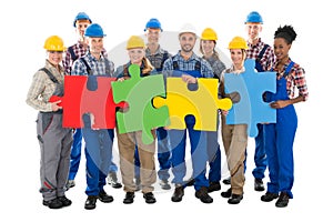 Confident Construction Workers Joining Jigsaw Pieces