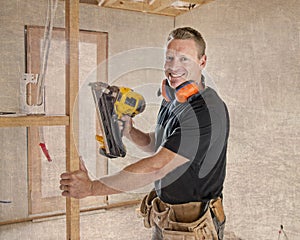 Confident constructor carpenter or builder man working wood with electric drill at industrial construction site in installation a