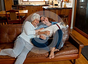 Couple relaxing at home and loving their pet. Positive image of life at home and New Normal