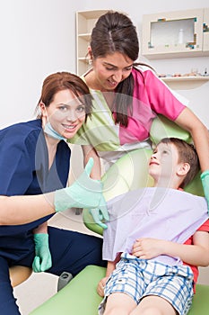 Confident dentist woman showing like with child patient