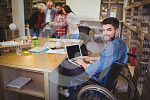 Confident disabled businessman using laptop at desk