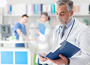 Confident doctor checking medical records