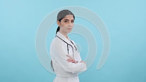 Confident doctor with crossed arms on blue background