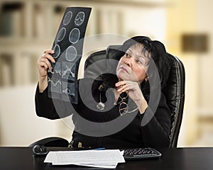 Confident doctor examines brain x-ray image closely