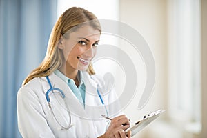 Confident Doctor Holding Clipboard In Clinic