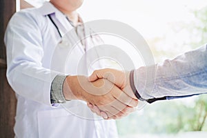 Confident Doctor shaking hands with patients talk in the hospit photo