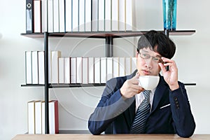 Confident elegant Asian business man holding coffee cup in office. Success celebration concept