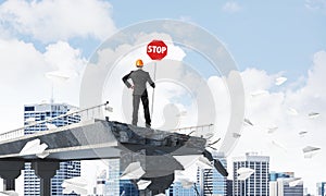 Confident engineer holding street safety sign.