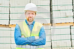 Confident engineer near building materials