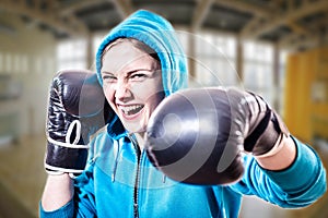 Confident excited sportsgirl in boxer gloves ready