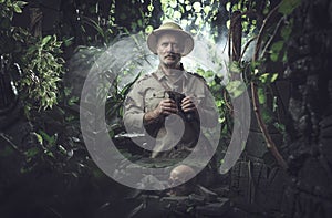Explorer with binoculars in the jungle photo