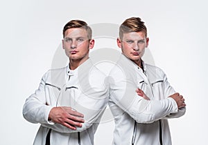 confident fashion models crossed hands. twins brother in white. male beauty and fashion