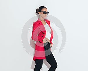 confident fashion woman with sunglasses looking to side and posing