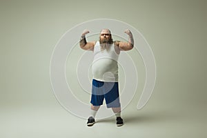 Confident fat man straining his muscles