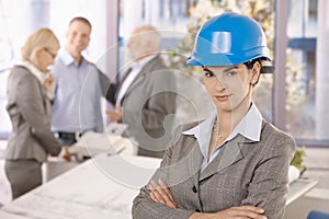 Confident female architect wearing hardhat