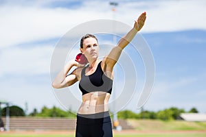 Confident female athlete preparing to throw shot put ball