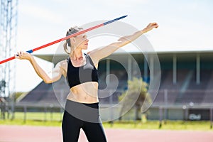 Confident female athlete about to throw a javelin