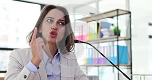 Confident female business executive giving a speech during a corporate meeting in a modern office