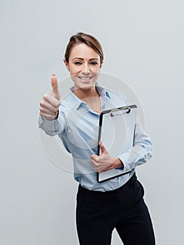 Confident female business executive giving a thumbs up