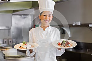 Confident female chef holding cooked food in kitchen