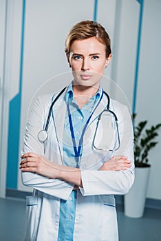 confident female doctor with crossed arms looking at camera