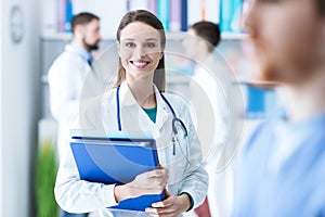 Confident female doctor holding medical records