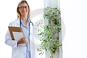 Confident female doctor looking at camera in the consultation.