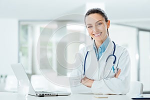 Confident female doctor at office desk