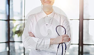 Confident female doctor posing in her office and smiling at camera, health care and prevention concept