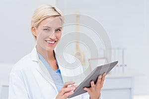 Confident female doctor using digital tablet