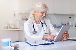 Female doctor using digital tablet in her office photo
