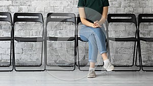 Confident female job seeker sitting in corridor of temp agency photo