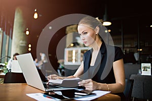 Confident female marketing specialist checking e-mail via portable netbook