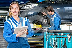 Confident Female Mechanic With Maintenance Checklist At Garage