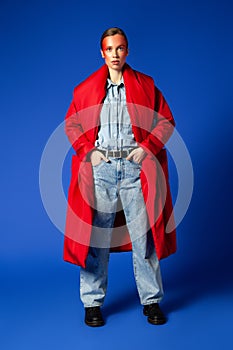Confident female model in baggy clothes against blue background
