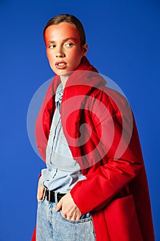 Confident female model in baggy clothes against blue background