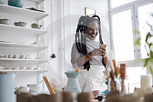 Confident female pottery artist in her art studio